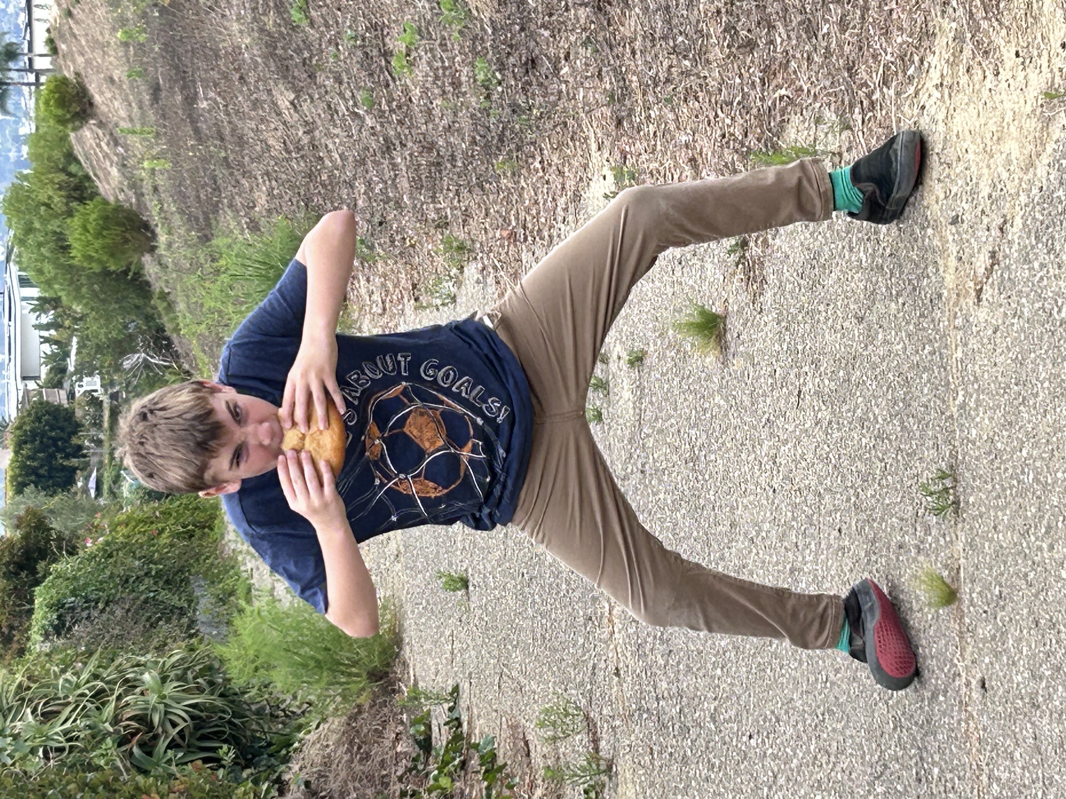 A kid enjoying a fresh pretzel outside